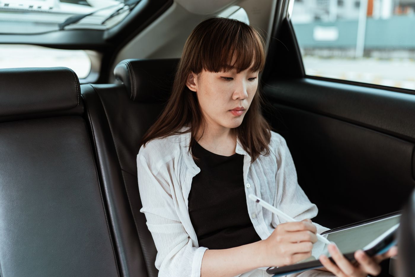 A field officer working on a tablet in the back of a car
