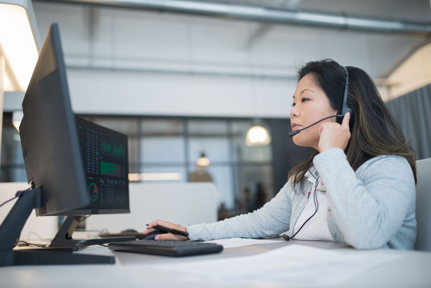 An operator in a headset working at a control room desk